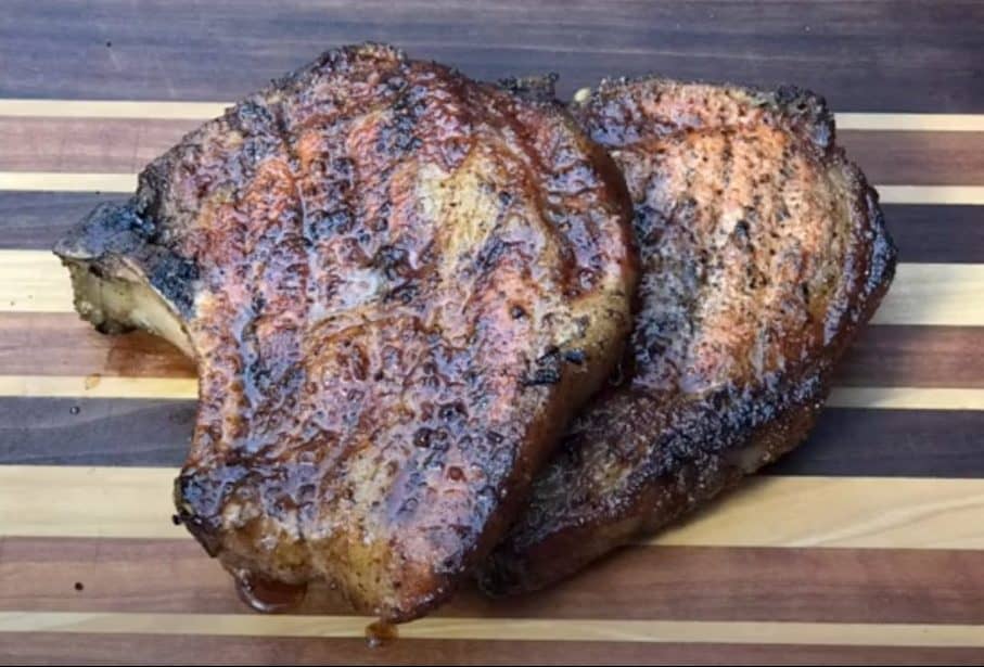 smoked pork chops from a pellet grill on a cutting board