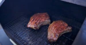 pork chops smoking on a pellet grill