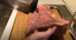 sprinkling rub on a hot and fast brisket