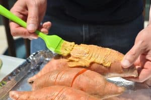 basting butter on sweet potatoes to smoke