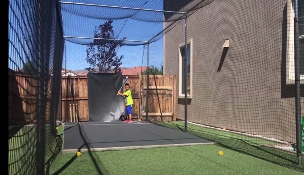 kids laying in a homemade batting cage 