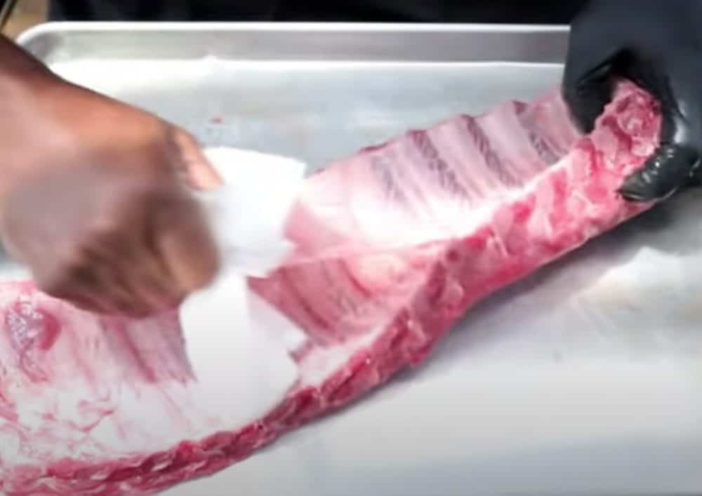 removing the membrane form the back of pork spare ribs with a paper towel