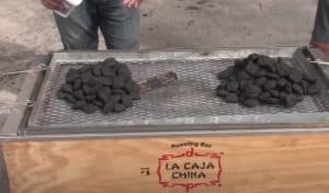 charcoal on a caja china roasting a pig