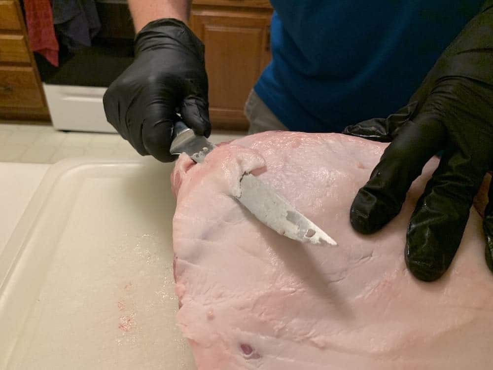 trimming the fat off a raw pork butt