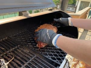 placing a pork butt back in a pit boss after unwrapping