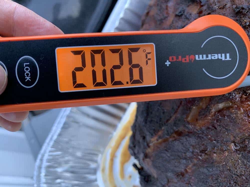 an instant thermomtere showing 202 degrees on a finished pork butt