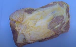 applying mustard to a pork butt