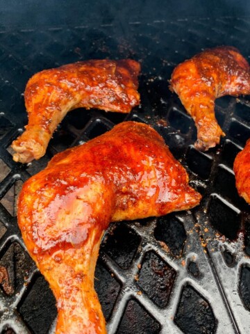 Chicken Leg Quarters on the grates of a pit boss pellet grill