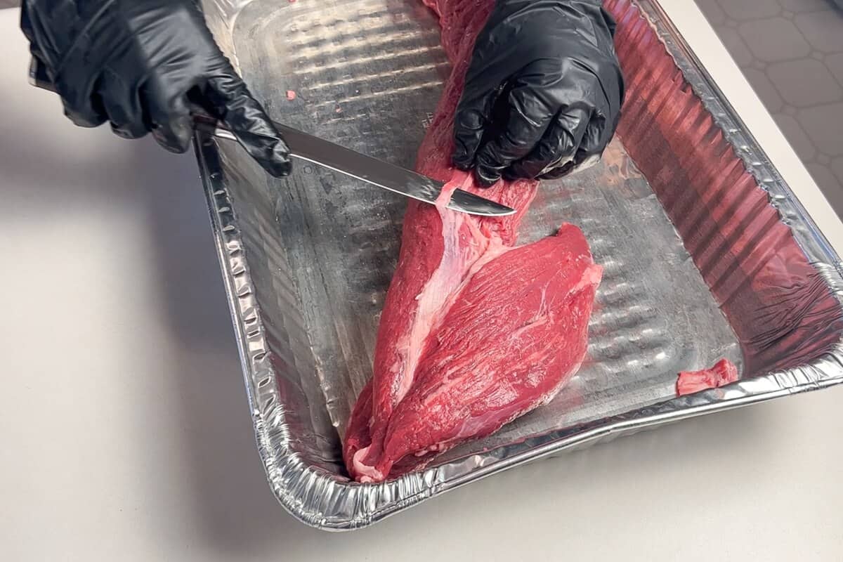 trimming the silverskin from beef tenderloin with a knife