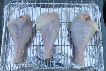 raw turkey legs on a wire rack drying after brining