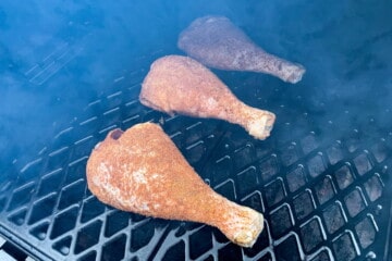 turkey legs smoking on the grates of a pit boss pellet grill