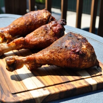 smoked turkey legs on a wooden cutting board