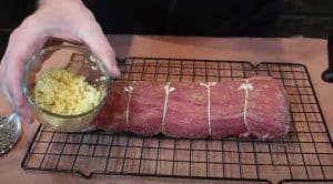 seasoning a beef tenderloin with fresh garlic