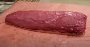 a trimmed beef tenderloin ready for the smoker