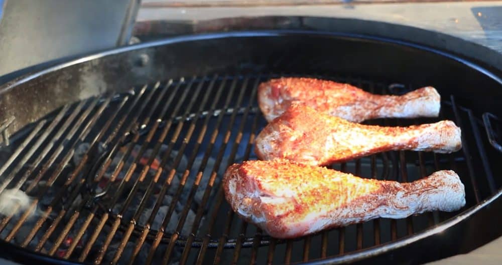 smoked turkey legs cooking indirectly over charcoal