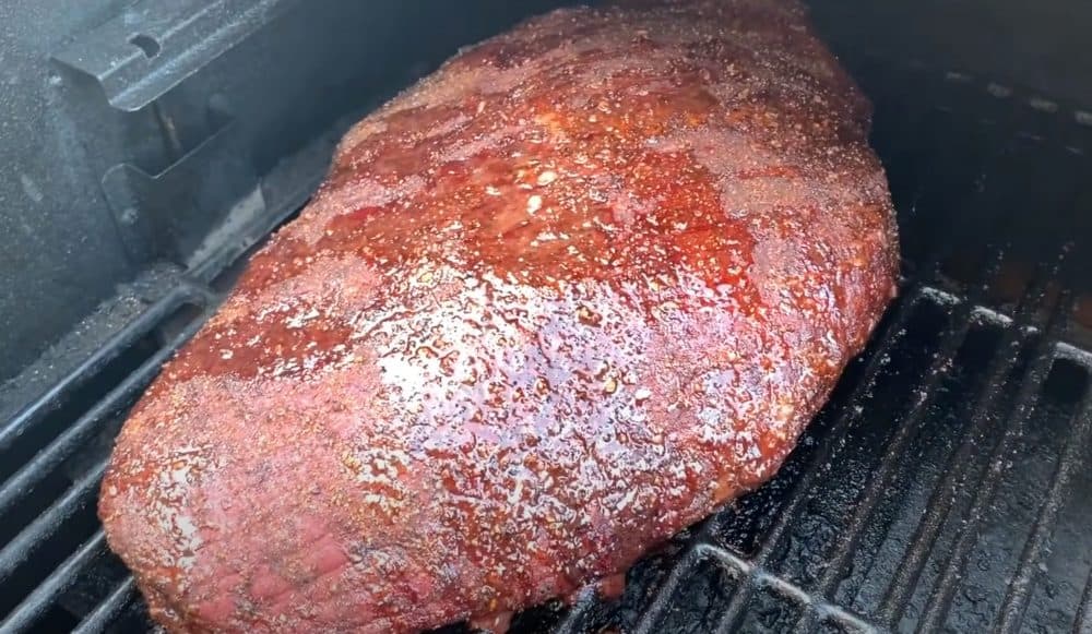 a beef brisket smoking on a traeger pellet grill