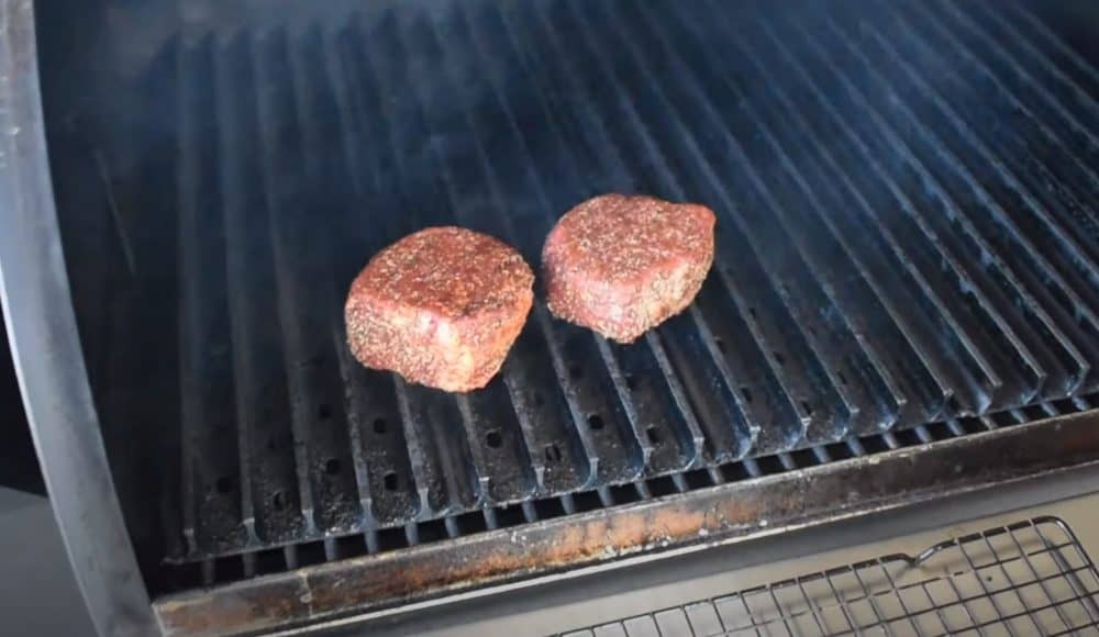 filet mignon steaks smoking on a traeger pellet grill with grill grates