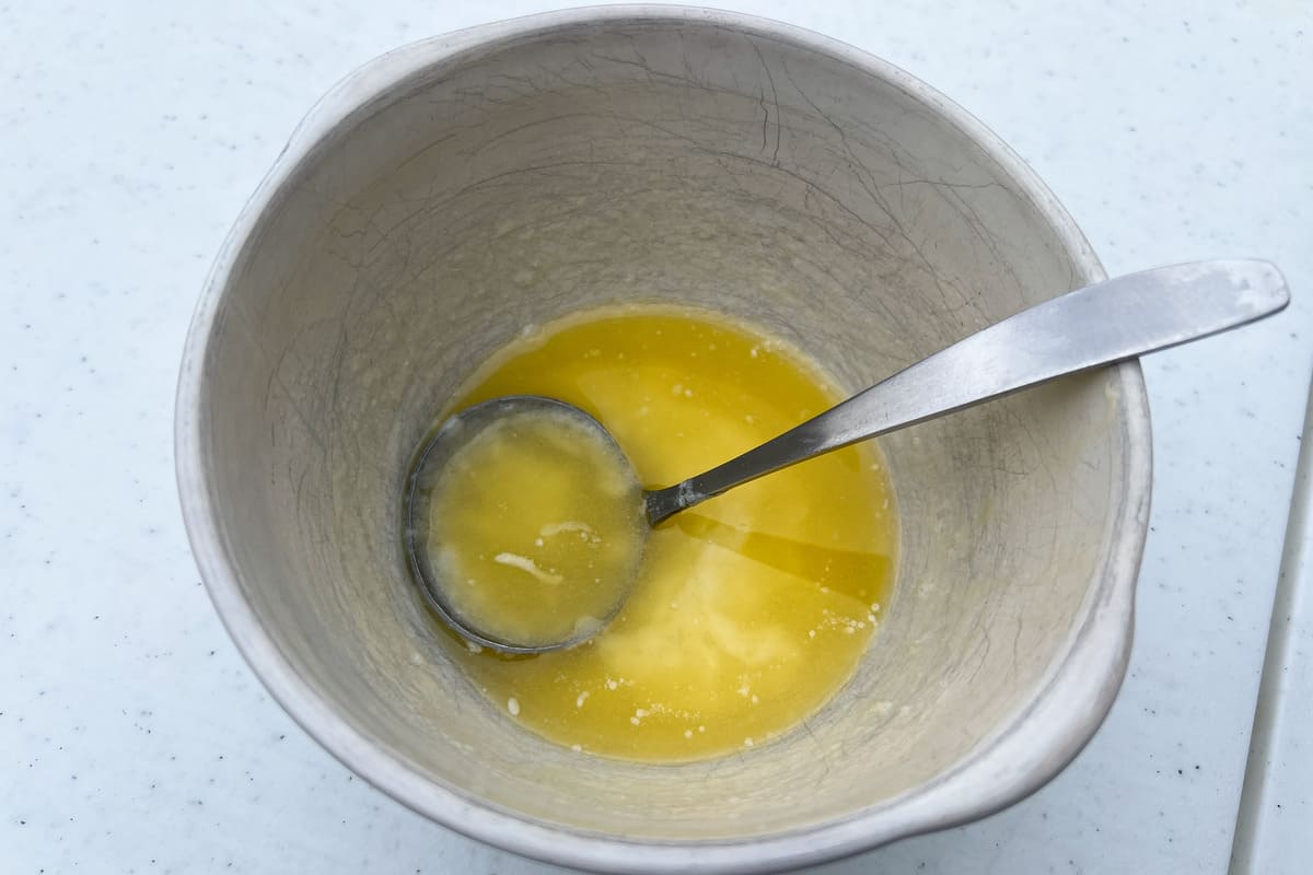 white bowl with melted garlic butter and a metal ladle