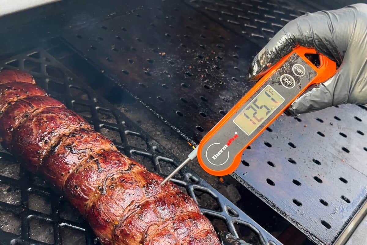 a beef tenderloin with an instant read thermometer reading 125 degrees F