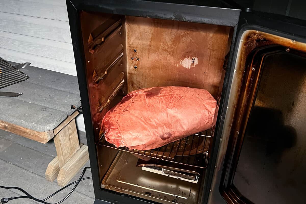 beef brisket wrapped in butcher paper inside a masterbuilt electric smoker