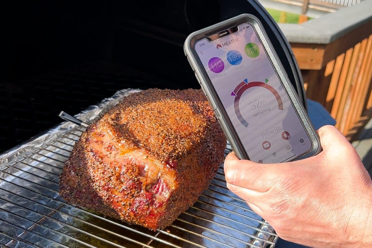 a smart phone displaying the MEATER app in front of a prime rib roast
