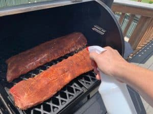 spraying baby back ribs on pit boss pellet grill