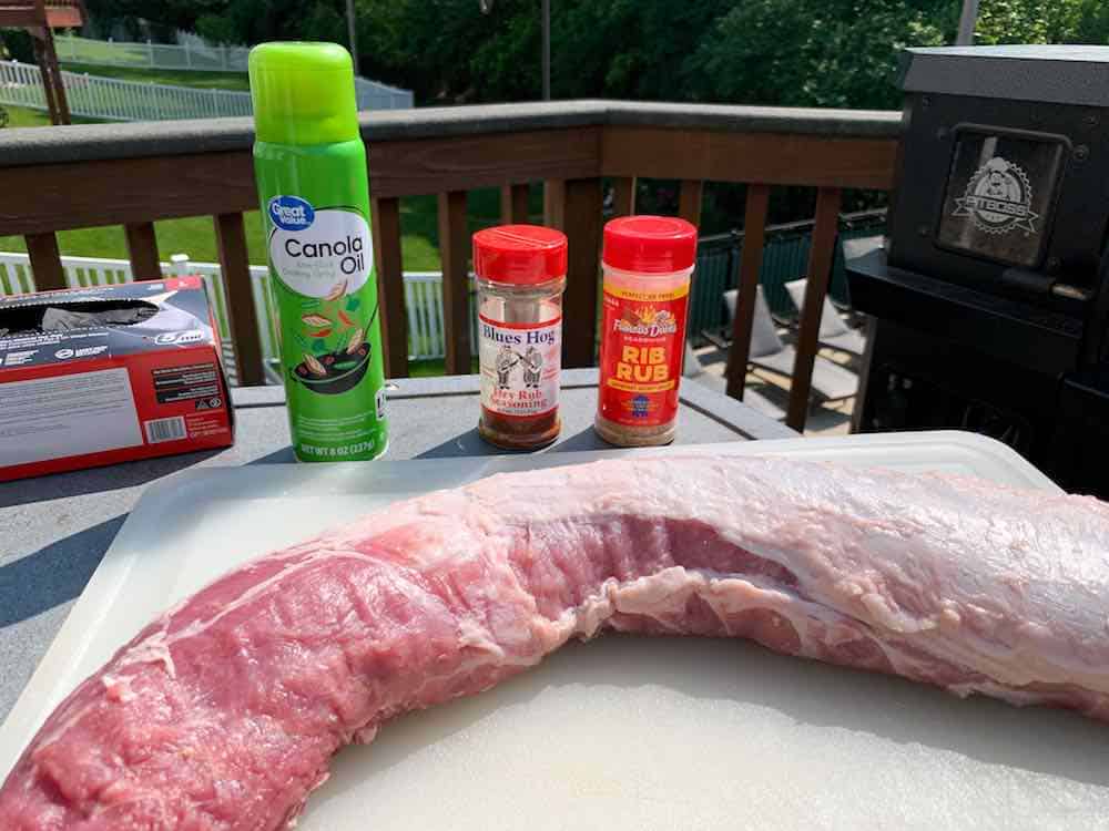 ingredients for smoked pork loin: oil spray, famous dave's rib rub, Blue's Hog seasoning, and the pork loin