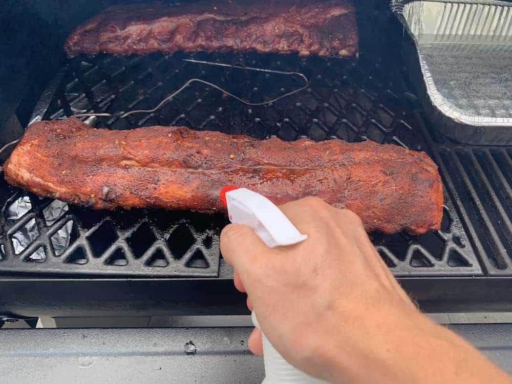 spraying baby back ribs on pit boss pellet grill