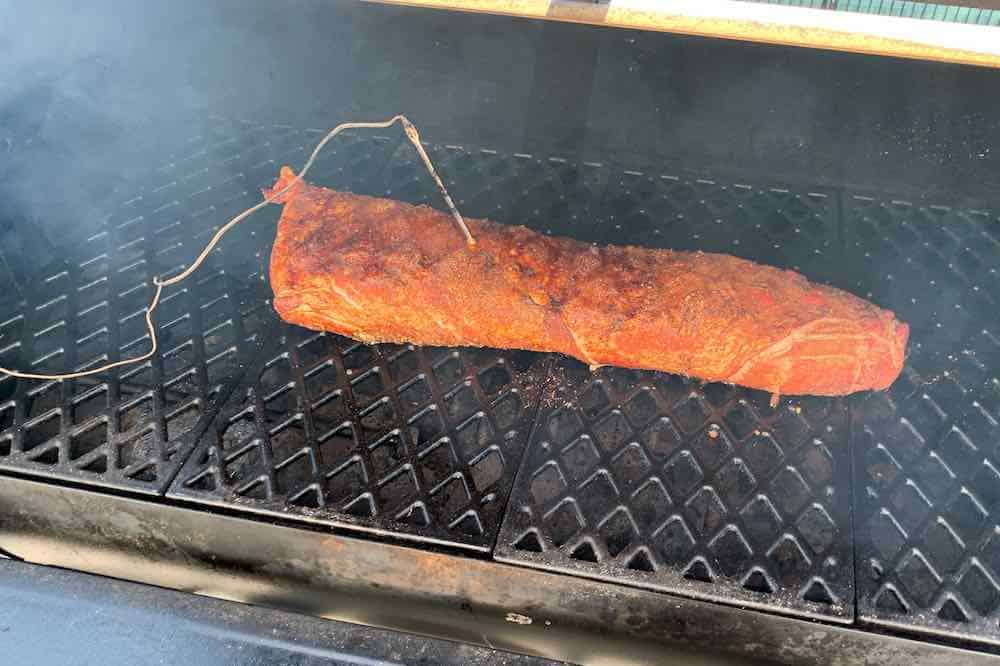 pork loin on a pellet grill with a leave in temperature probe in the meat