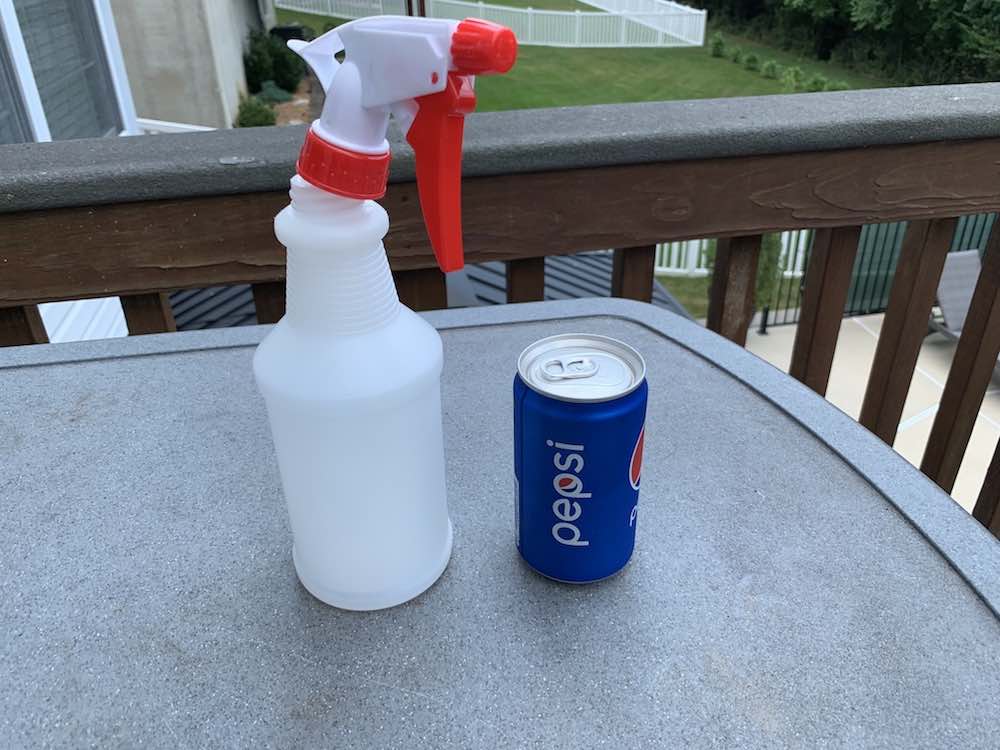an empty spray bottle and a can of pepsi