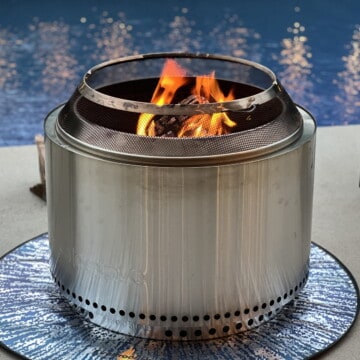lit solo stove on concrete in front of a pool