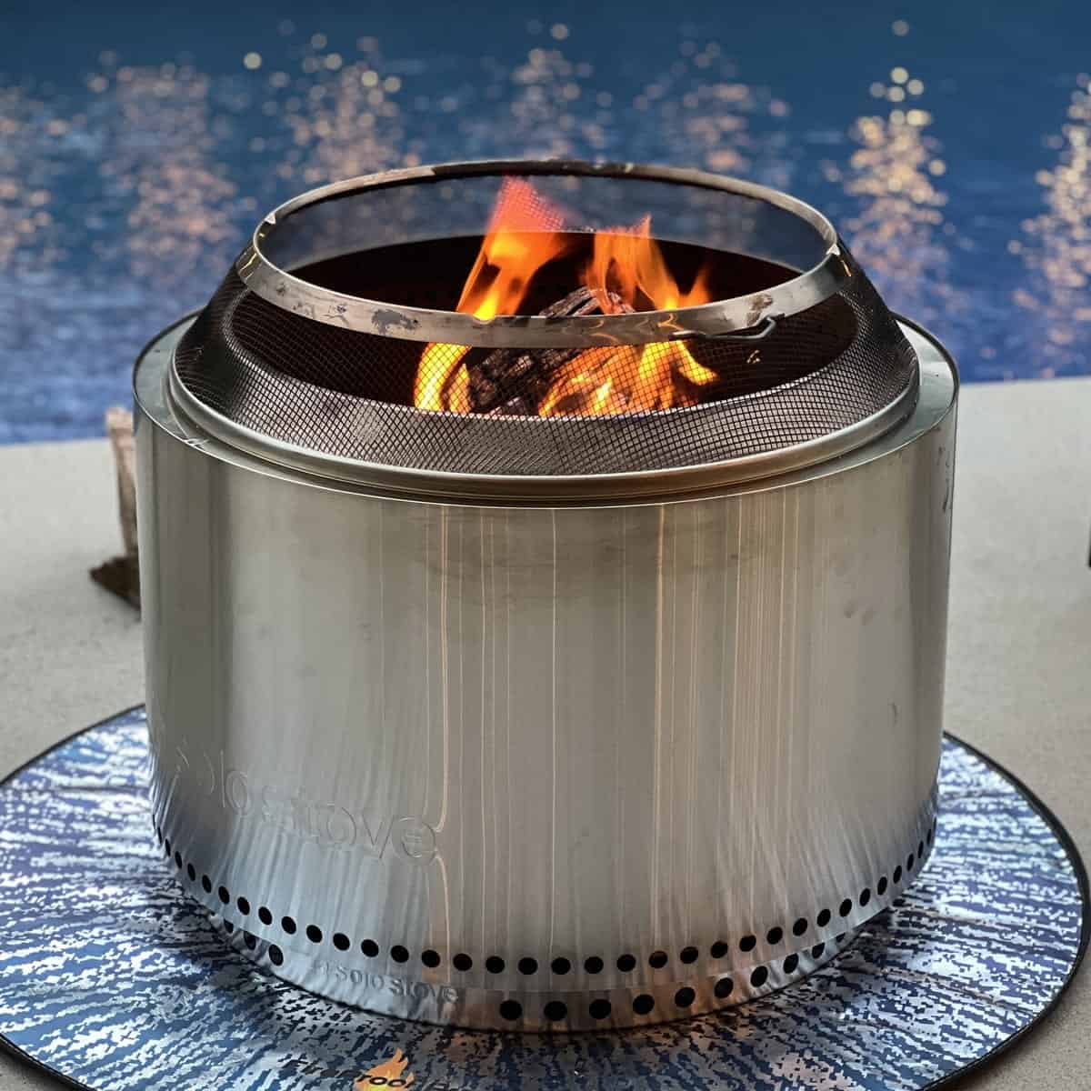 lit solo stove on concrete in front of a pool