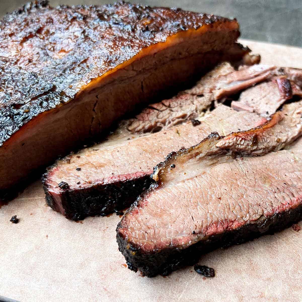 smoked beef brisket sliced on a wood cutting board