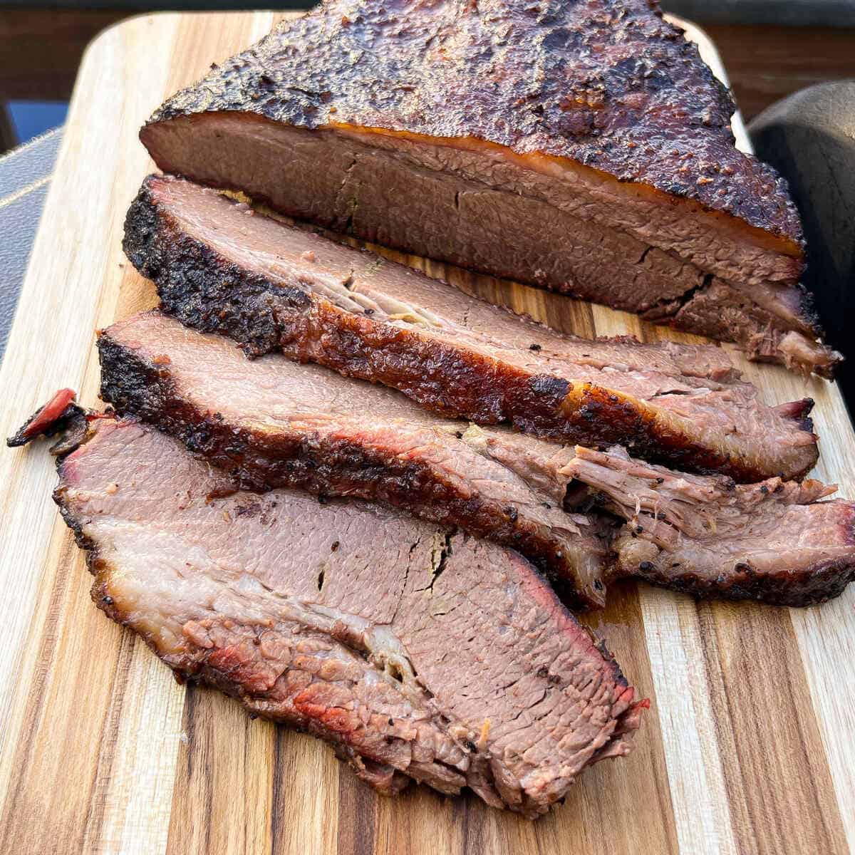 smoked brisket sliced on a wooden cutting board