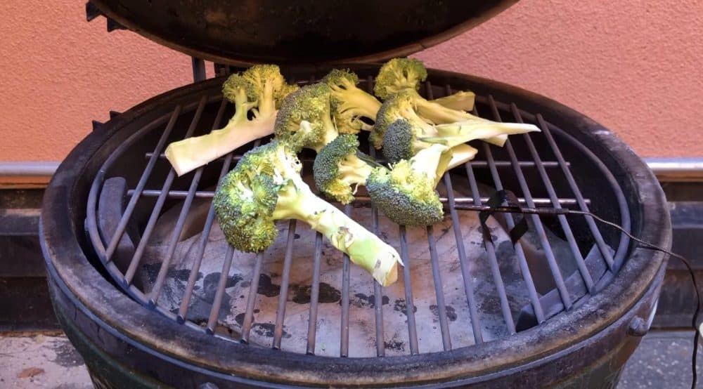 placing broccoli on a smoker to smoke