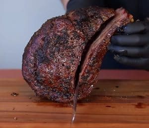 slicing the bones off a smoked prime rib roast