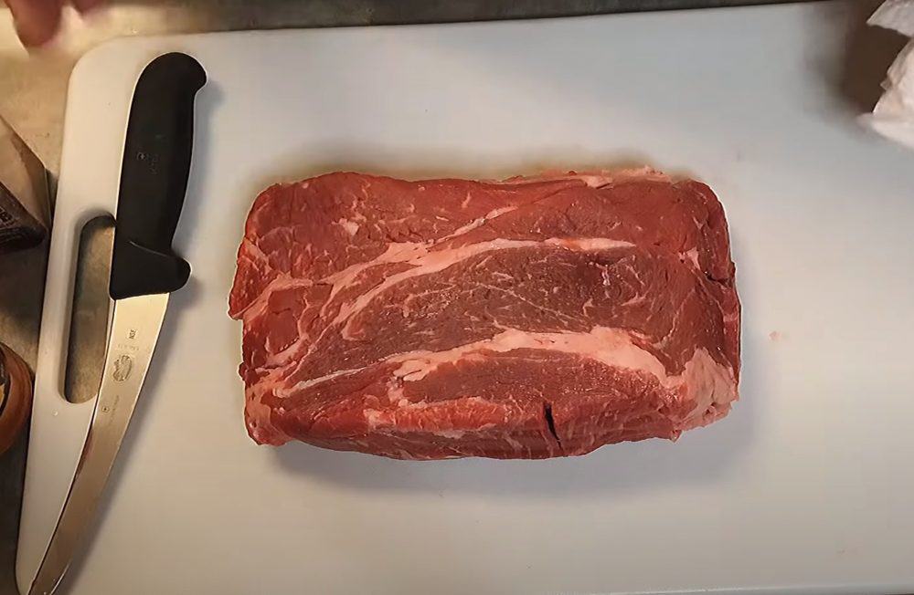 a raw chuck roast on a cutting board
