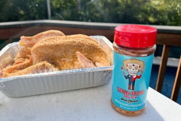 bottle of Texas Sugar BBQ Rub from Meat Church on a table in front of a seasoned whole chicken