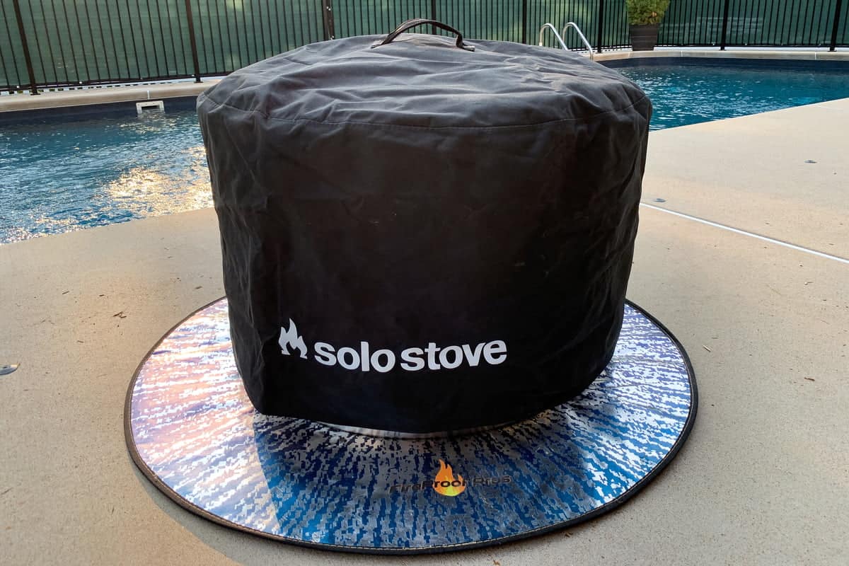 Solo Stove with cover on top on a concrete pool deck