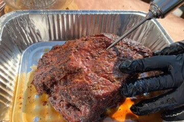 a meat injector injecting marinade into a partially cooked chuck roast