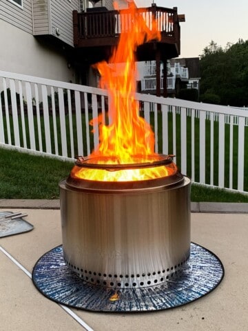 a solo stove with a large flame shooting up