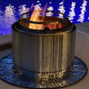 solo stove lit in front of a pool at night