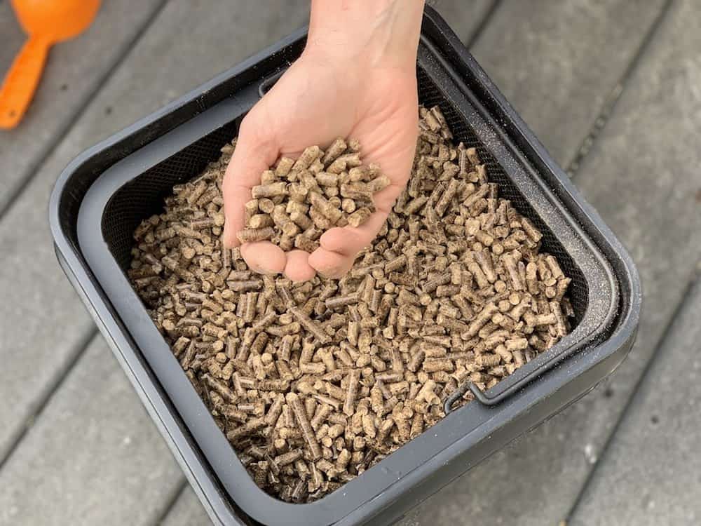 a hand holding wood pellets