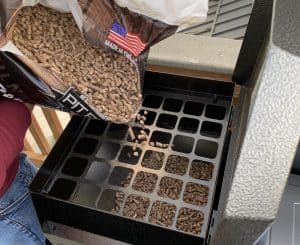 pouring pellets in a pit boss hopper