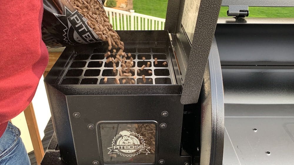 pouring pellets into a pit boss pellet grill hopper