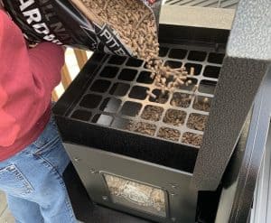 pouring pellets into a pit boss pellet grill hopper