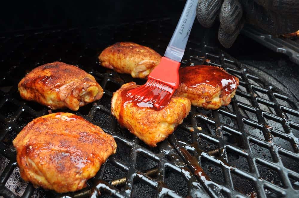 saucing smoked chicken thighs on a pit boss pellet grill