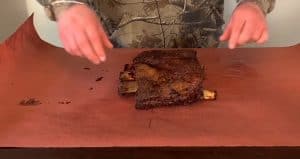 wrapping smoked beef ribs in pink butcher paper