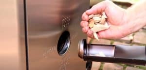 loading wood chips into a masterbuilt electric smoker