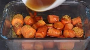 pouring honey balsamic glaze on smoked carrots